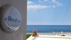 a sign on a building with the ocean in the background at Case Vacanza Marzano in Monopoli
