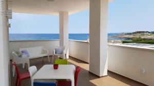 a balcony with a table and chairs and the ocean at Case Vacanza Marzano in Monopoli