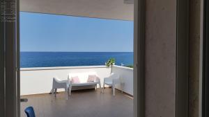 a balcony with a table and chairs and the ocean at Case Vacanza Marzano in Monopoli
