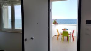 a table and chairs in a room with a view of the ocean at Case Vacanza Marzano in Monopoli