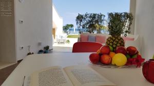a book and a bowl of fruit on a table at Case Vacanza Marzano in Monopoli