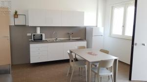 a kitchen with a white table and a white refrigerator at Case Vacanza Marzano in Monopoli
