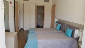 a bedroom with two beds and a bathroom at Case Vacanza Marzano in Monopoli