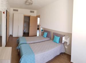 a bedroom with two beds with blue pillows at Case Vacanza Marzano in Monopoli