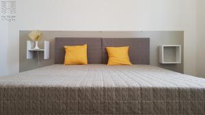 a bedroom with a large bed with yellow pillows at Case Vacanza Marzano in Monopoli