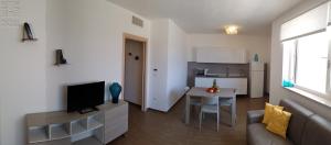 a living room with a couch and a television and a table at Case Vacanza Marzano in Monopoli