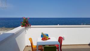 un tavolo e sedie su un balcone con vista sull'oceano di Case Vacanza Marzano a Monopoli