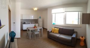 a living room and kitchen with a couch and a table at Case Vacanza Marzano in Monopoli