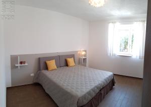 a bedroom with a bed with two yellow pillows at Case Vacanza Marzano in Monopoli