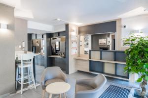 a living room with chairs and a table and a bar at B&B HOTEL Valence Nord in Bourg-lès-Valence