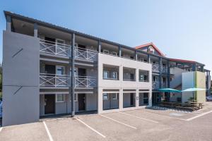 una vista exterior de un edificio con aparcamiento en B&B HOTEL Valence Nord, en Bourg-lès-Valence