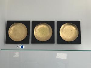 three gold and black framed images of planets on a wall at Golden View Residence in Dhërmi