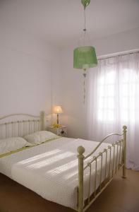 a bedroom with a white bed and a green lamp at Villa Kedros in Kalamaki Heraklion
