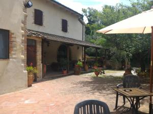 un patio con tavolo, sedie e un edificio di Borgo Montauto a San Gimignano