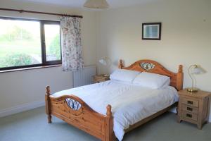 una camera con letto in legno e finestra di Tyddyn Crwn Country-House Apartments a Beaumaris