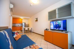 uma sala de estar com um sofá e uma televisão de ecrã plano em Splendid Resort em Pula