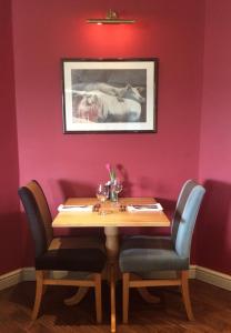 una mesa en una habitación con una pared rosa en The Craven Arms en Settle