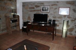 Uma televisão e/ou sistema de entretenimento em Alojamento Rural Casa da Eira