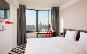 a hotel room with a bed and a desk with a view at AZIMUT Hotel Smolenskaya Moscow in Moscow