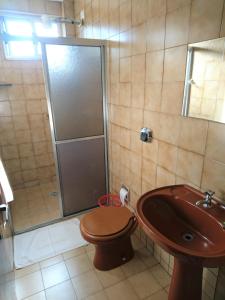 uma casa de banho com um chuveiro, um WC e um lavatório. em Santa Maria Hotel em Cascavel