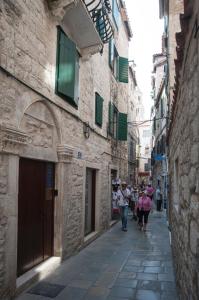a group of people walking down a narrow alley at Grgur Ninski Rooms in Split