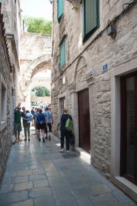 a group of people walking down a stone alley at Grgur Ninski Rooms in Split