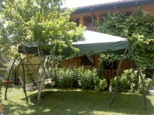 a tent in a garden with a tree at Pensiunea Casa Beatrice in 2 Mai