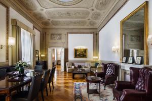 a living room filled with furniture and a large window at Relais Santa Croce, By Baglioni Hotels in Florence