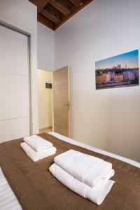 Un dormitorio con una cama con toallas blancas. en Lyon Cosy Stay, en Lyon