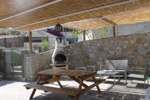 a patio with a table and a wood stove at Casa Azzurra 3 camere e 2 bagni in Fetovaia