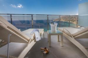 a balcony with chairs and a table with a view of the ocean at ESTIMAR Calpe Suitopia in Calpe