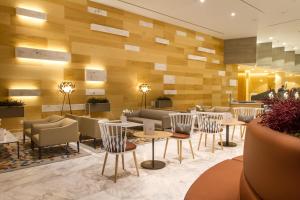 a restaurant with tables and chairs in a lobby at ESTIMAR Calpe Suitopia in Calpe