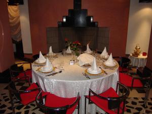 une table avec un tissu de table blanc et des chaises rouges dans l'établissement El Pueblo Tamlelt, à Agadir 37 autres photos