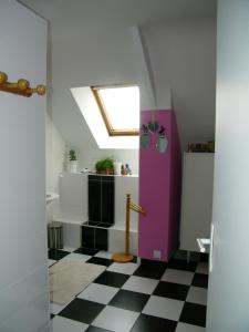 a bathroom with a pink door and a checkered floor at Chambre d'hotes La Jaunais in Virey