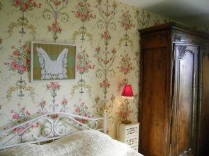 a bedroom with a bed and floral wallpaper at Chambre d'hotes La Jaunais in Virey