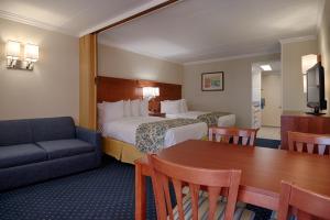 een hotelkamer met een bed, een tafel en een bank bij The Spinnaker in Ocean City