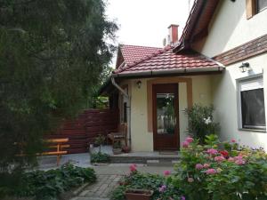 uma casa com uma porta de madeira e um banco em Vargapartman em Szeged