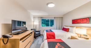 una camera d'albergo con due letti e una scrivania di Kwa'lilas Hotel a Port Hardy Altre 21 foto