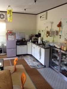 a small kitchen with white cabinets and appliances at Narita Airport Hostel in Shibayama