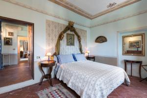 a bedroom with a bed with blue and white sheets at Villa Lysis in Lastra a Signa +47 photos