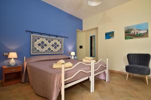 a bedroom with a bed and a chair at B&B Issicoro in Baunei