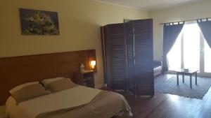 a bedroom with a bed and a large window at A Casa do Lado in Horta