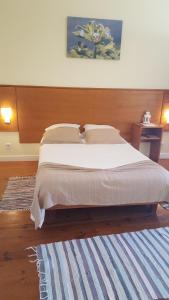 a bedroom with a large bed with a wooden headboard at A Casa do Lado in Horta