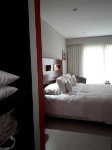 Un dormitorio con una cama con sábanas blancas y una ventana. en Aires del Norte, en Federación 24 fotos más