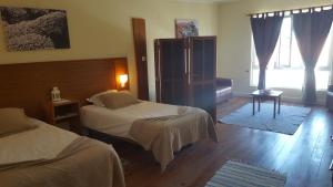 a bedroom with two beds and a large window at A Casa do Lado in Horta