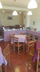 a restaurant with tables and chairs with red and white checks at A Casa do Lado in Horta