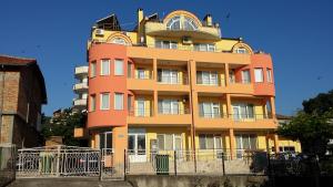 a tall yellow and orange building at Zlatevi Guest House in Obzor