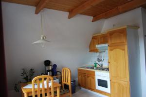 a kitchen with wooden cabinets and a table and a sink at Ferienwohnung-Stricker-Typ-A-Balkon-1-3 in Walkenried