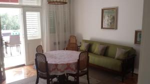a living room with a table and a couch at Apartments Prisnac in Pakoštane