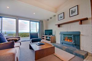 a living room filled with furniture and a fire place at Beacon Point Ocean View Villas in Apollo Bay